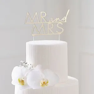 Guldfärgad Mr och Mrs-cake topper på vit bröllopstårta
